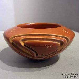 Sgraffito heart line and bear paws on a red bowl carved with a bear design