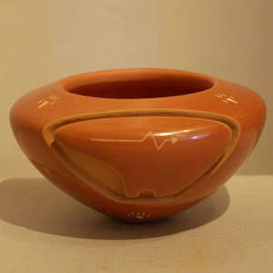 Bear design carved into a red jar with sgraffito heart line and bear paws