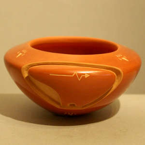 Sgraffito heart line and bearpaws design on a red bowl carved with a bear design