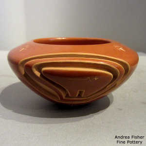 Bear design carved into a red bowl with sgraffito bear paws and heart line