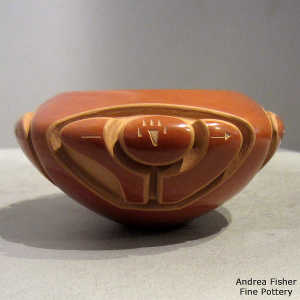 Sgraffito bear paw, heart line and geometric design on a red bowl carved with a bear design