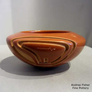 Sgraffito bear paws on a red bowl carved with a bear design