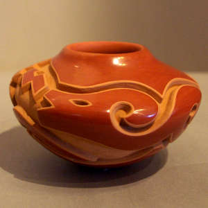 An avanyu design carved into a red bowl