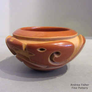 Avanyu and geometric design carved into a red bowl