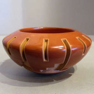 Geometric designs carved into a polished red jar