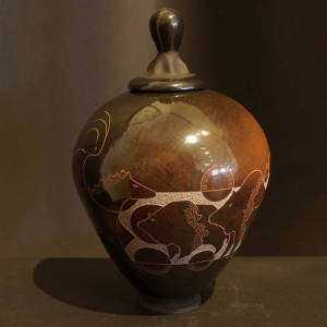 Sgraffito buffalo, horse and geometric designs on a brown and black jar