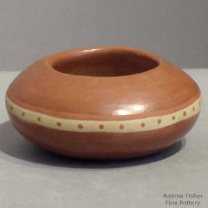 A dot design decorates a miniature red bowl