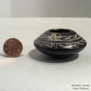 Miniature black bowl decorated with a sgraffito avanyu and geometric design
