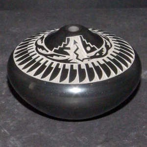 Sgraffito feather and avanyu design on a polished black seedpot
