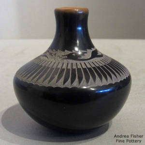 Sgraffito avanyu design on a miniature black jar with a sienna rim