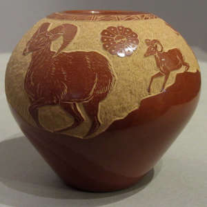 Sgraffito ram design on a red jar