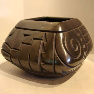 Geometric design carved into a square black jar