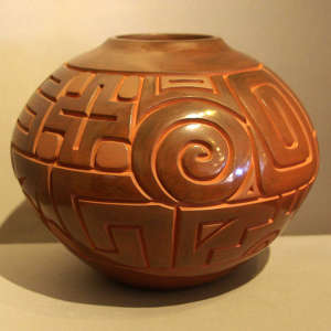 Cross, Tularosa spiral and geometric design carved into a polished brown jar
