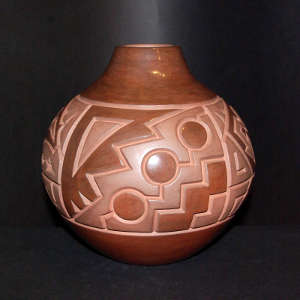 Carved stylized bear and geometric design on a brown on brown jar