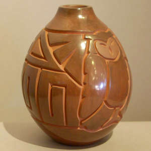 Owl and geometric design carved into a brown jar