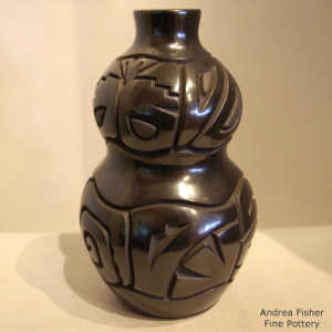 Butterfly and geometric design carved into a black double jar