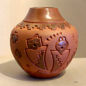 Geometric design and yei figures carved into a red jar