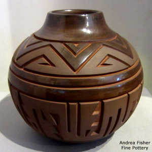 Geometric design carved into a brown on brown jar