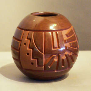 Liva step and geometric design carved into a red matte on red jar