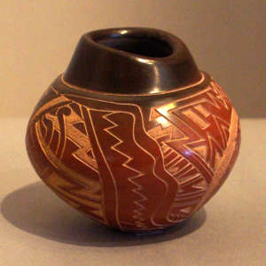 Sgraffito geometric design on a black jar with sienna body