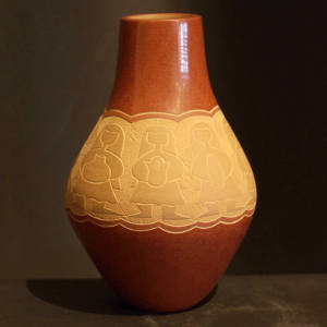 Sgraffito design of women holding pots decorates a polished red jar