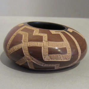 Sgraffito geometric design on a small brown bowl