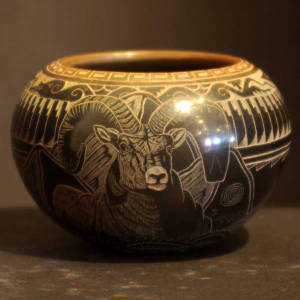 Sgraffito wildlife and feather motif on a black jar with a sienna rim