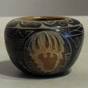 Sgraffito wildlife designs and sienna spots on a black jar