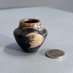 Sgraffito nature, wildlife and geometric design on a miniature black jar with a sienna rim