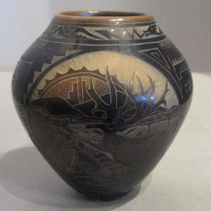 Sgraffito wildlife designs and sienna spots on a black jar