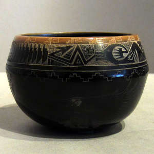 Sgraffito geometric designs with a sienna rim on a black jar