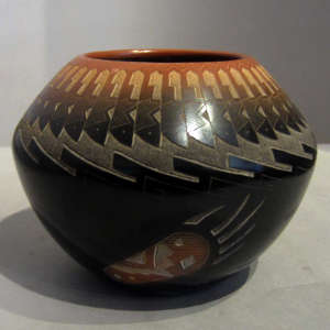 Sgraffito avanyu, feather and geometric designs with bear paw, sienna spots and sienna rim on a black jar
