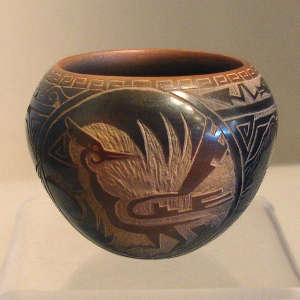 Sgraffito roadrunner, avanyu and geometric design on a black jar with sienna rim and spots