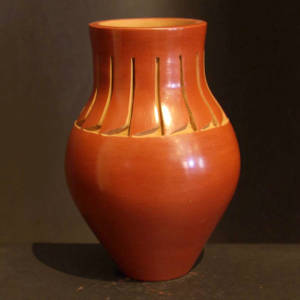 Feather design carved into a tall red vase