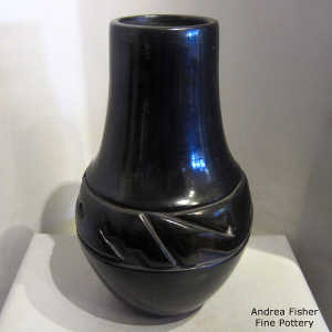 Geometric design carved into a tall neck black jar
