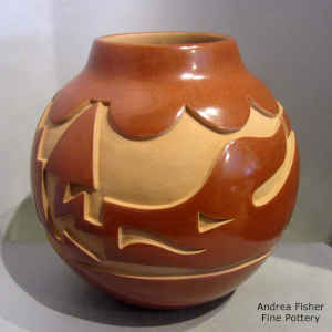 Red jar carved with an avanyu design