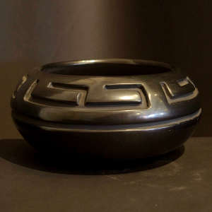 Geometric design craved into a low black open bowl