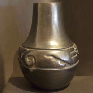 Geometric design carved into a polished tall neck black jar