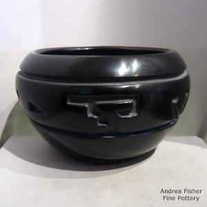 A 4-direction geometric design carved into a black bowl