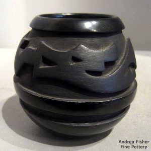 An avanyu design carved into a black on black jar