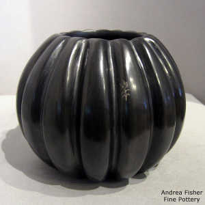 Sgraffito corn figure on a carved black melon jar