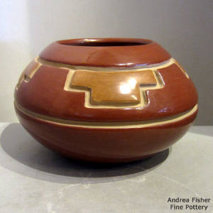Kiva step and geometric design carved into a red jar with brown cloud accents