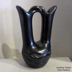Avanyu design carved into a black wedding vase with a twisted handle