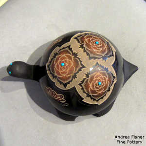 Sgraffito flower and geometric design on a carved black turtle with sienna spots and inlaid stones