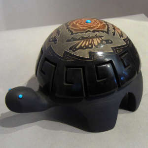 Sgraffito floral, butterfly and geometric designs on a carved black turtle with sienna spots and inlaid turquoise
