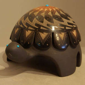 Carved geometric design with sgraffito feather and geometric design on a black turtle with inlaid turquoise