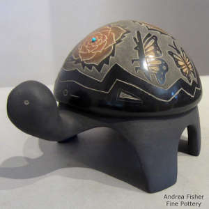 Sgraffito butterfly and floral design on a carved black turtle with sienna spots and inlaid turquoise