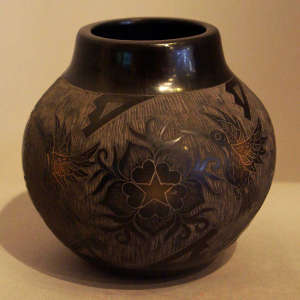 Sgraffito hummingbirds, flowers and geometric designs on a black jar