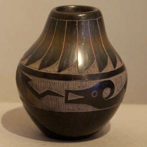 Sgraffito feather and avanyu design on a black jar