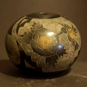 Sgraffito hummingbird and flower design on a black jar with sienna spots